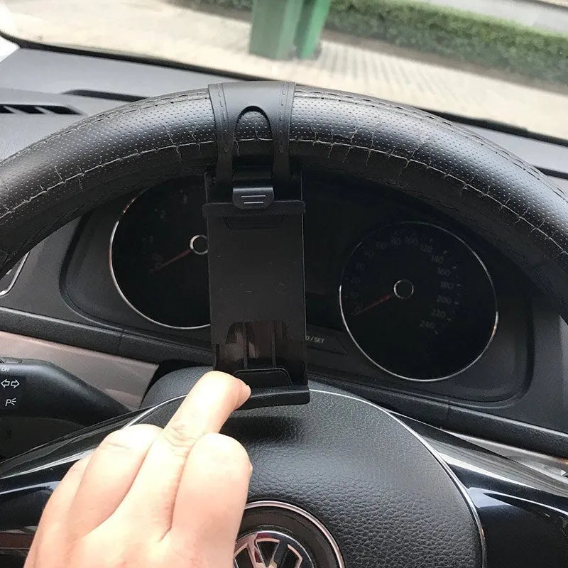 Black universal steering wheel phone holder clip mount attached to a car steering wheel.