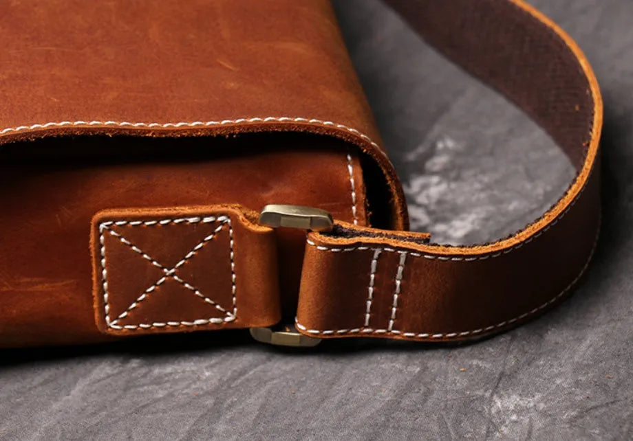 Men's vintage brown cowhide shoulder bag showing medium size and cross-body strap