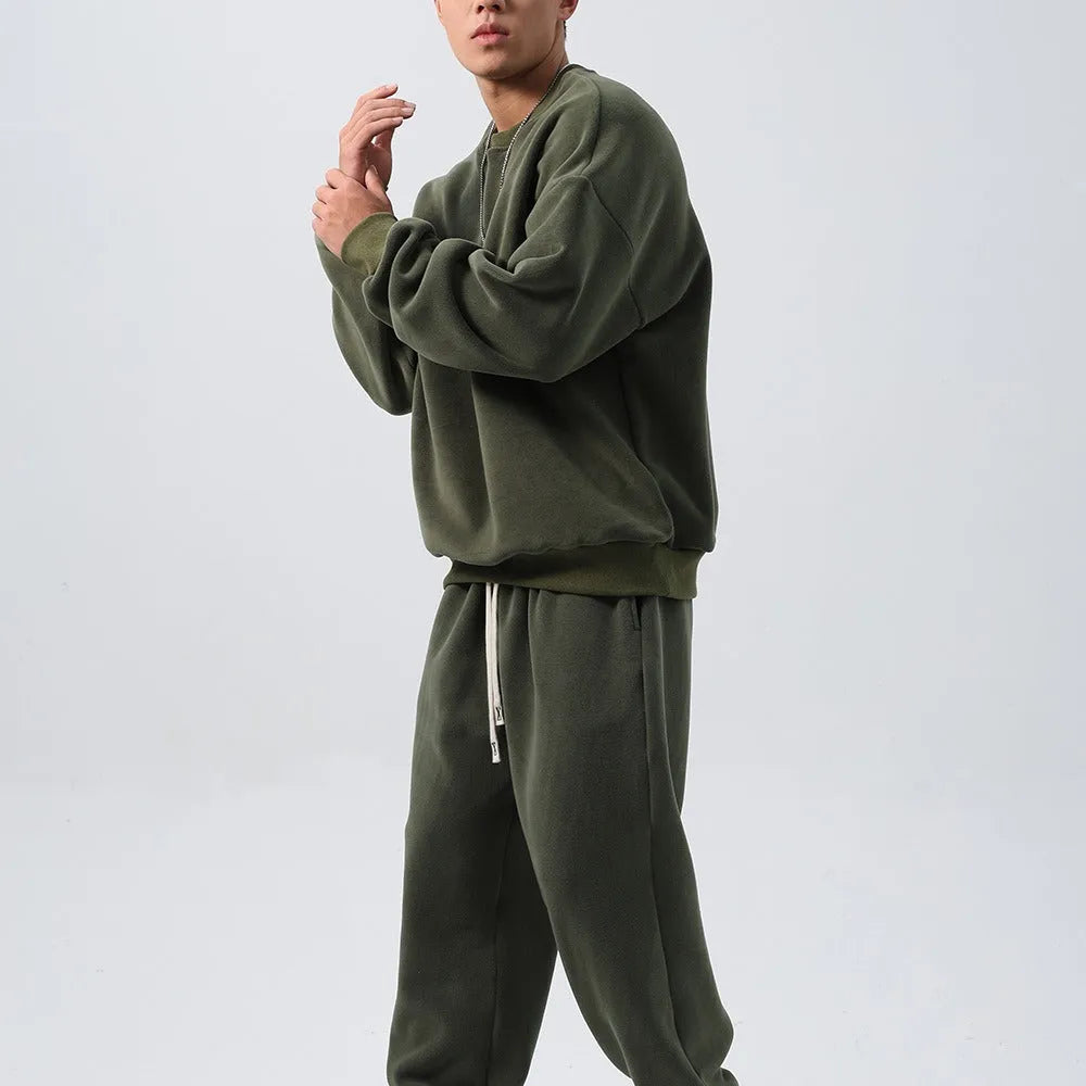 Man wearing a black polar fleece sports suit with a crew neck coat and loose trousers.
