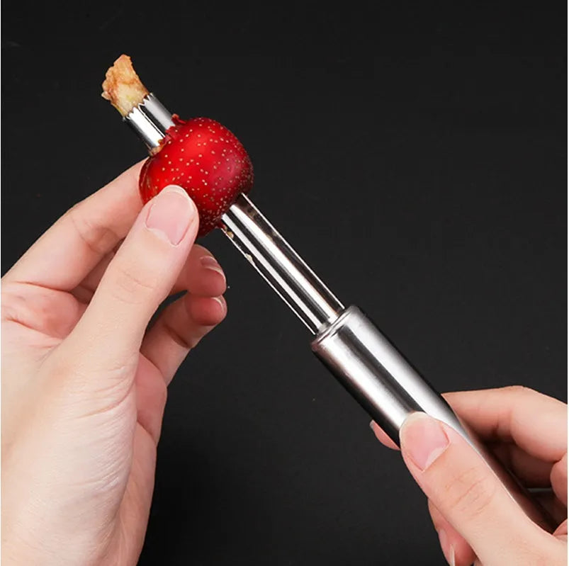 Stainless steel pineapple corer slicer with coloured plastic handle on a kitchen worktop.