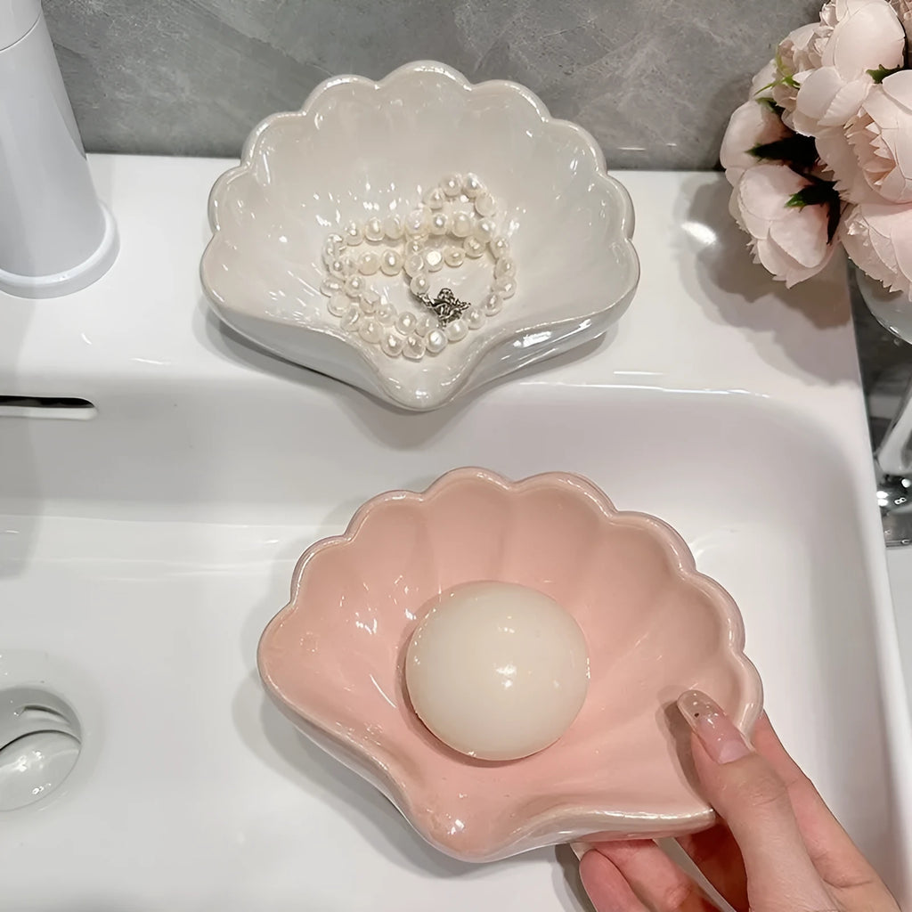 White or pink plastic shell-shaped soap dish for bathroom use