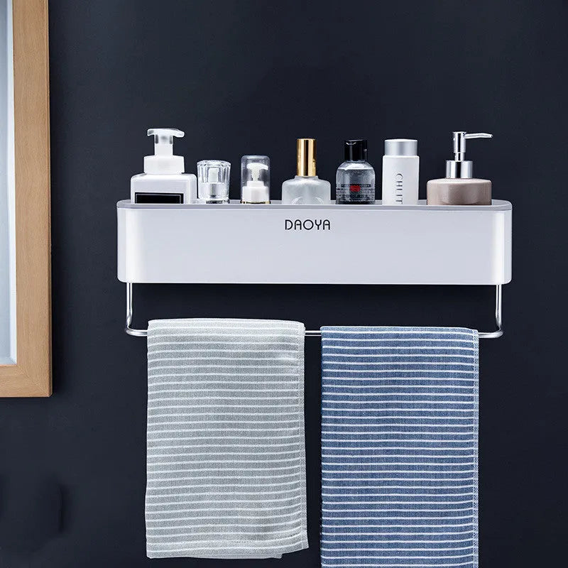 Black adhesive plastic bathroom shelf mounted on a wall holding shampoo and shower gel bottles.