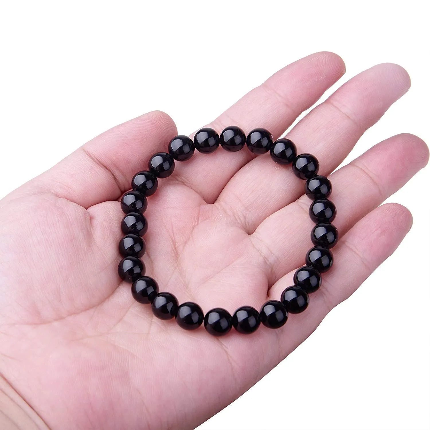 Close-up of a black agate bracelet with 8mm geometric beads on a black elastic cord.