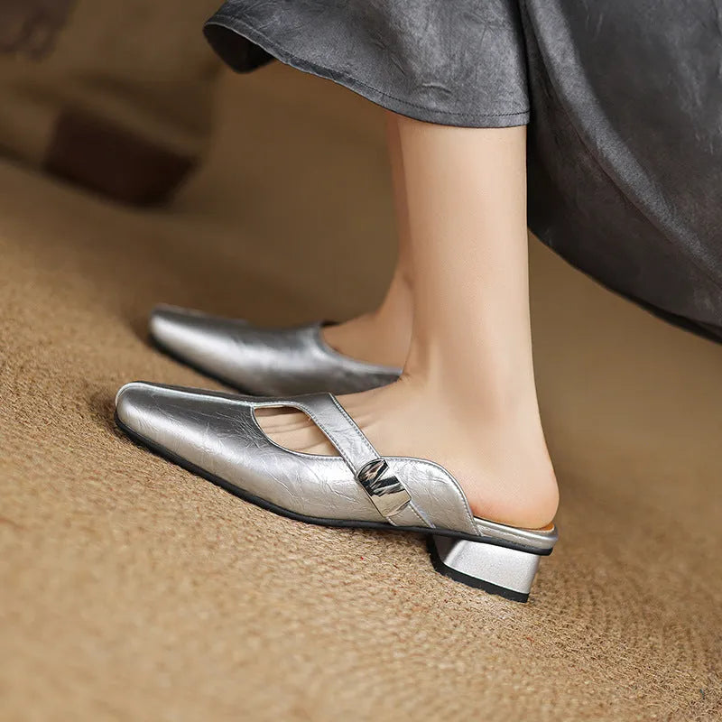 A pair of casual square-toe low-heel slippers in a solid colour on a rubber sole.
