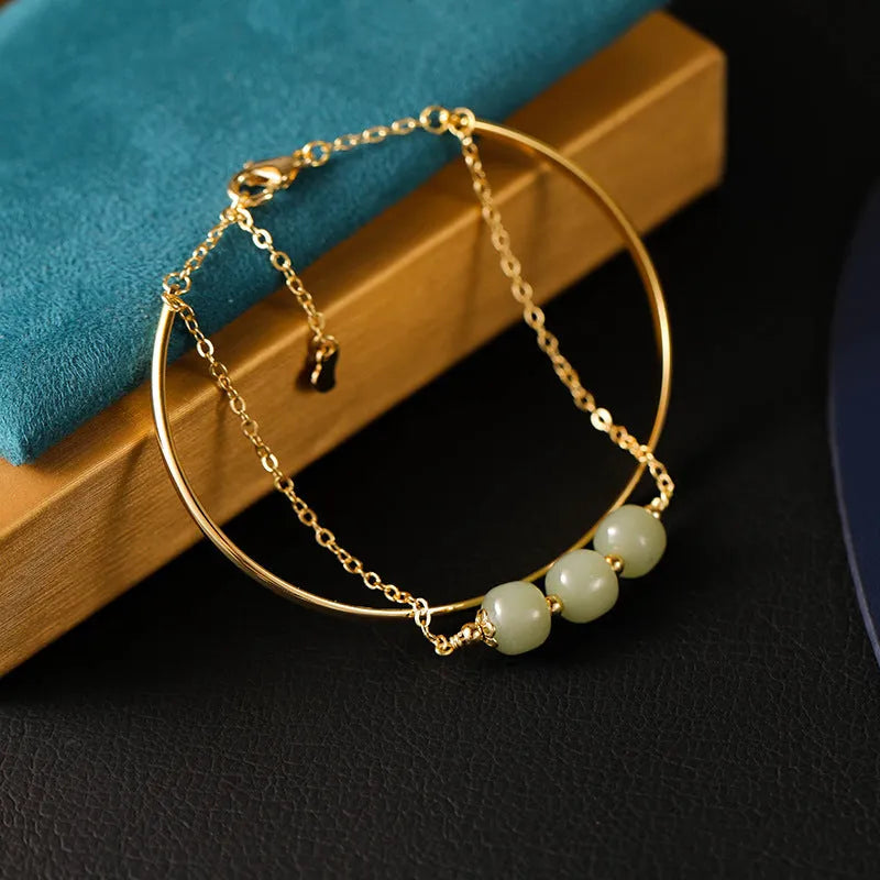 Women's jade bracelet with gold inlay lucky bead design in single, double, or three bead versions.