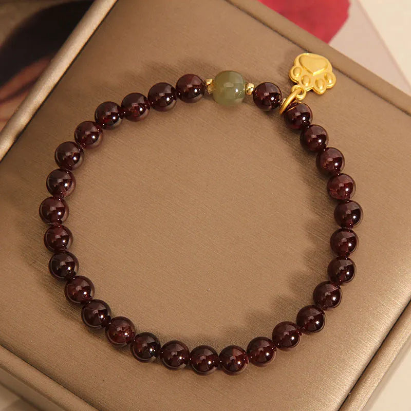 Women's adjustable crystal bracelet with a cat's paw shaped garnet stone centrepiece.