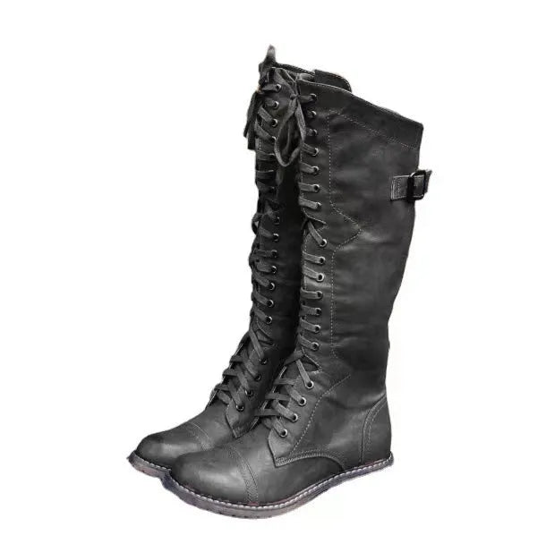 Women's black chunky heel high leg boots with a round toe and low heel on a plain background.
