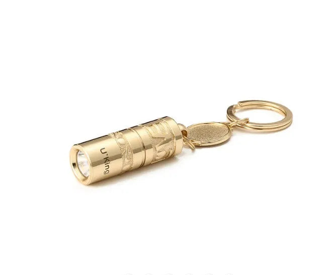 Gold electroplated zinc alloy portable LED keychain flashlight for outdoor emergency use.