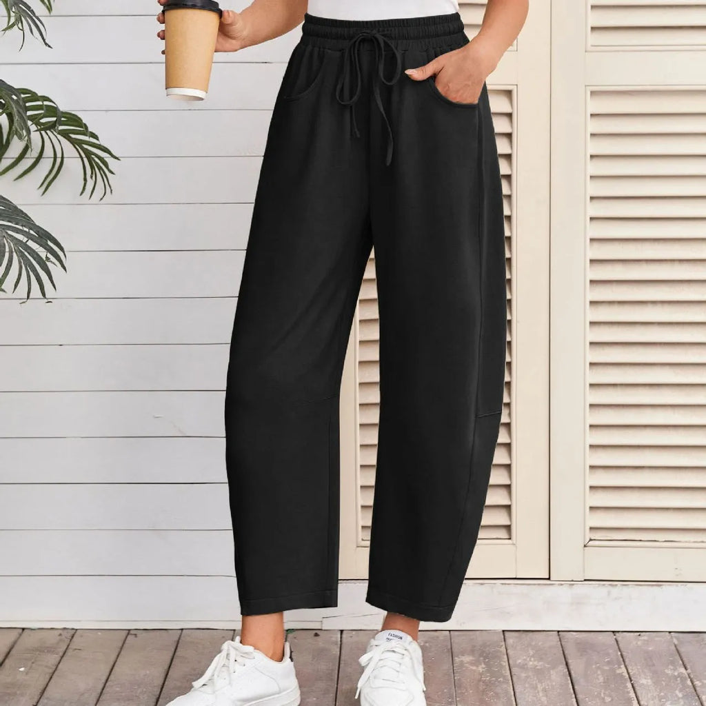 Loose fit cropped sweatpants in apricot colour with drawstring waist and side pockets on a neutral background.