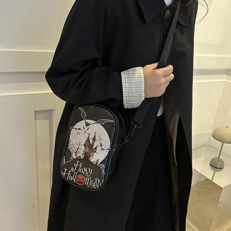 Women's black mini crossbody bag with orange Halloween pumpkin graffiti print.