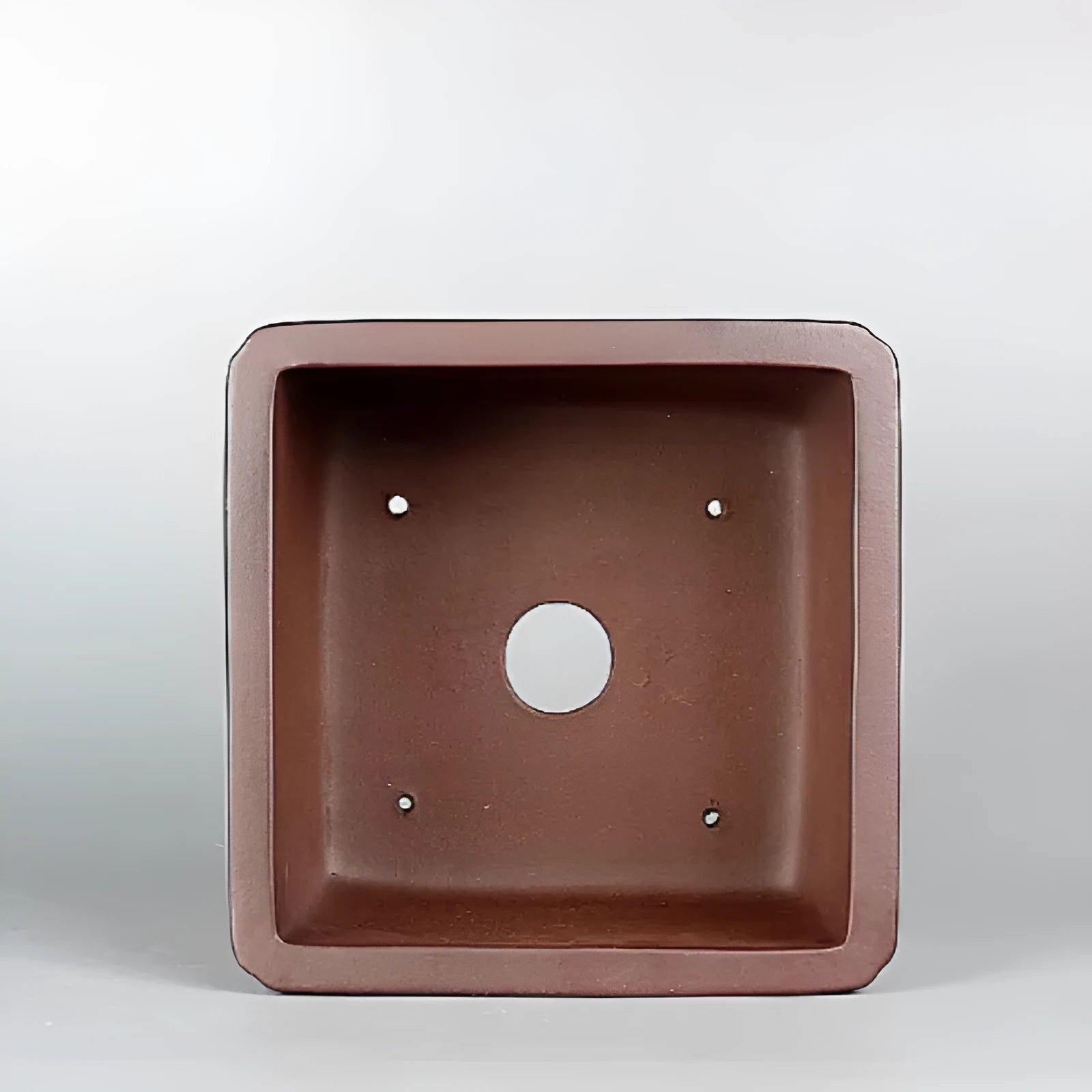 Handmade brown antique purple clay classical flower pot with a drainage hole.