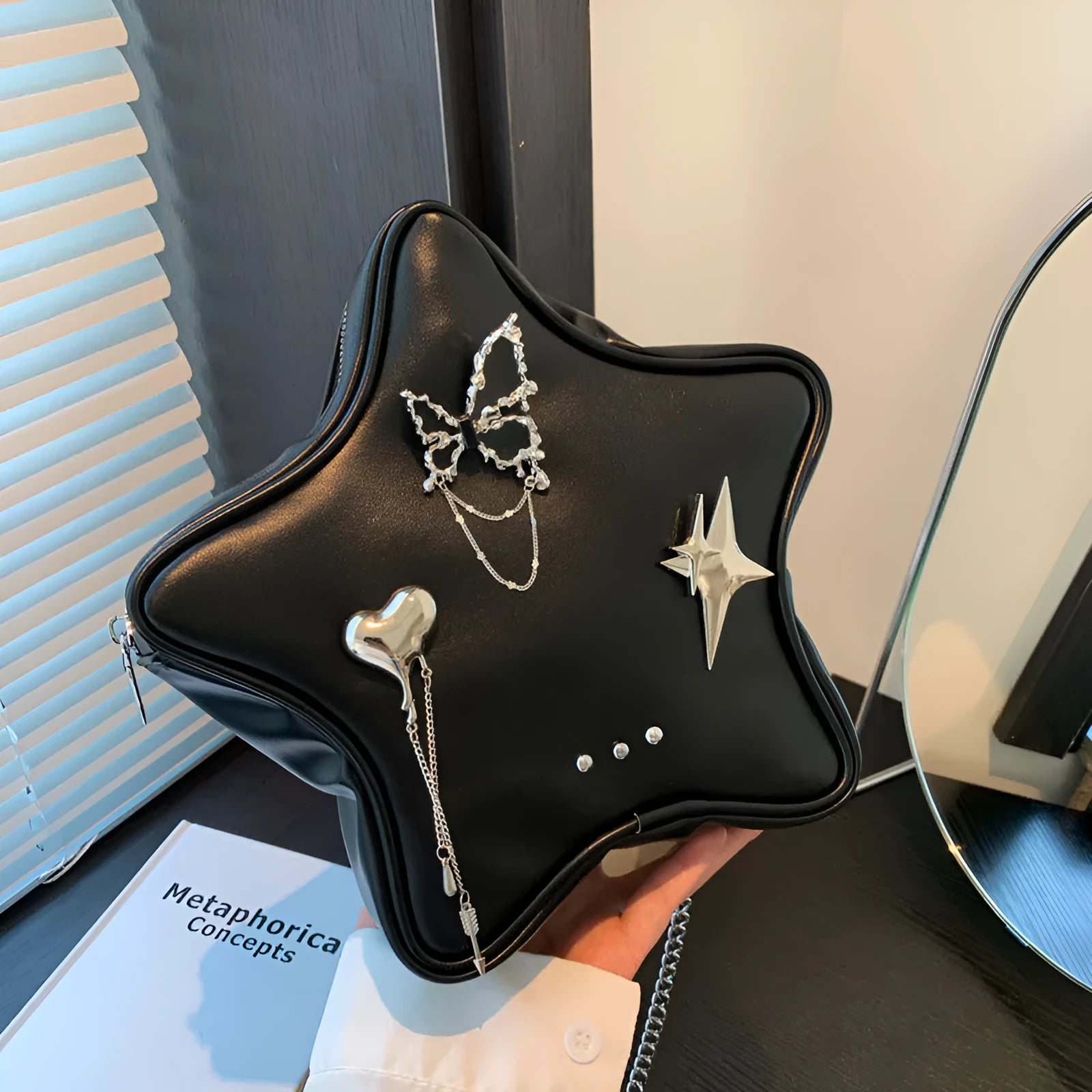 Black PU leather street style backpack with a detachable star-shaped butterfly pendant and chain strap.