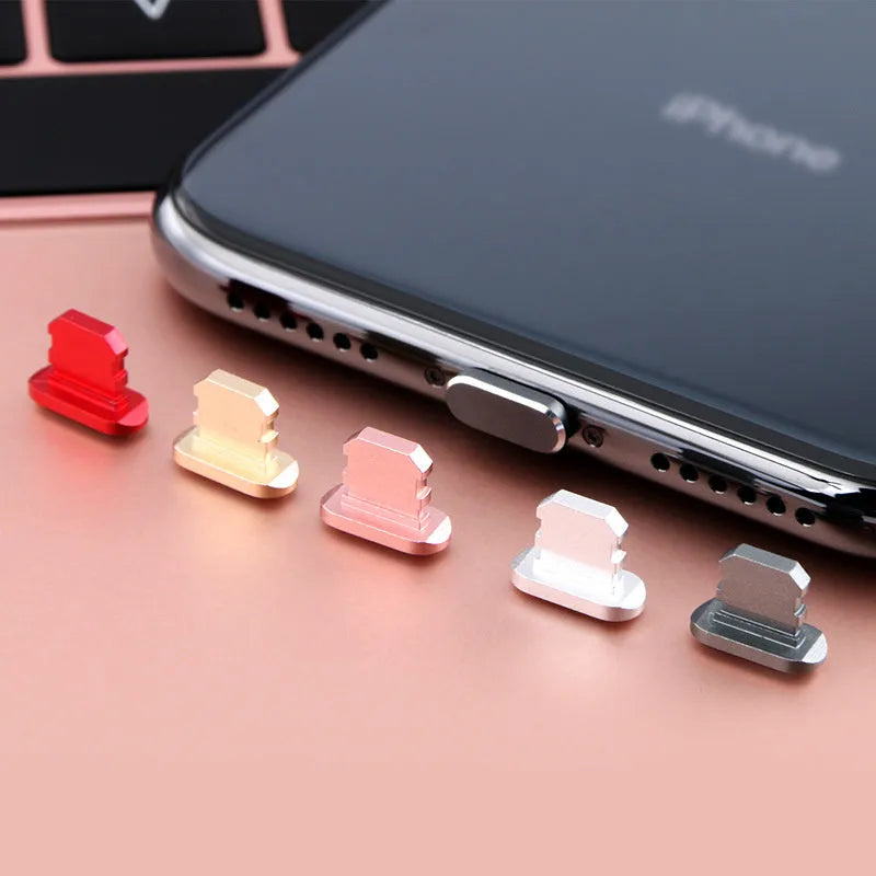 Aluminium alloy iPhone charging port dust plug shown in gold, silver, and rose gold colours.