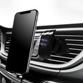 Black car phone holder attached to a car air vent, clamping a smartphone.