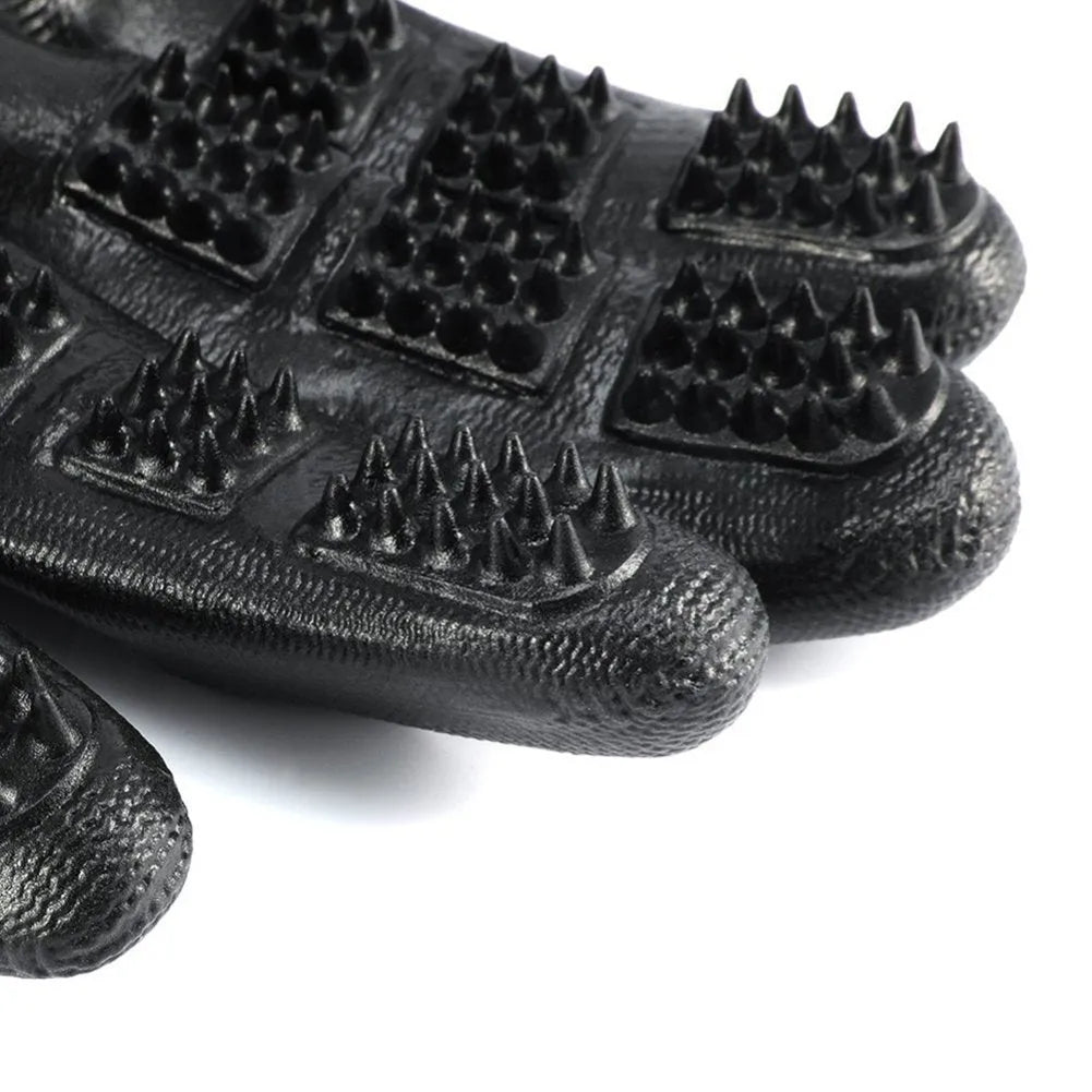 Pet hair grooming glove in black rubber with adjustable wrist strap on a light background