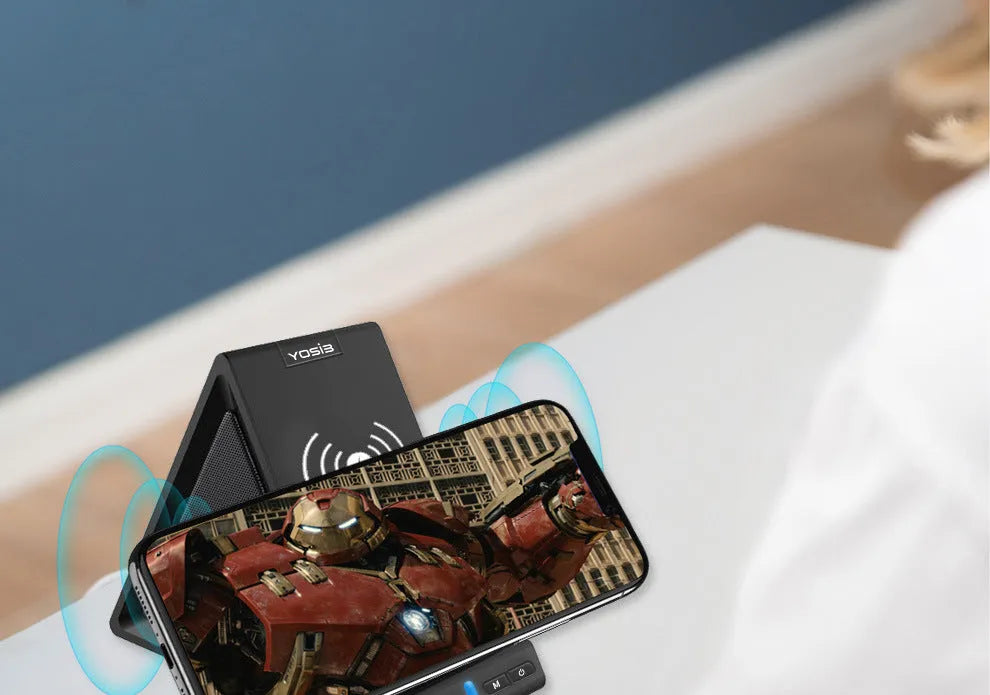 Black multifunctional Bluetooth speaker with integrated wireless charging pad and phone stand.