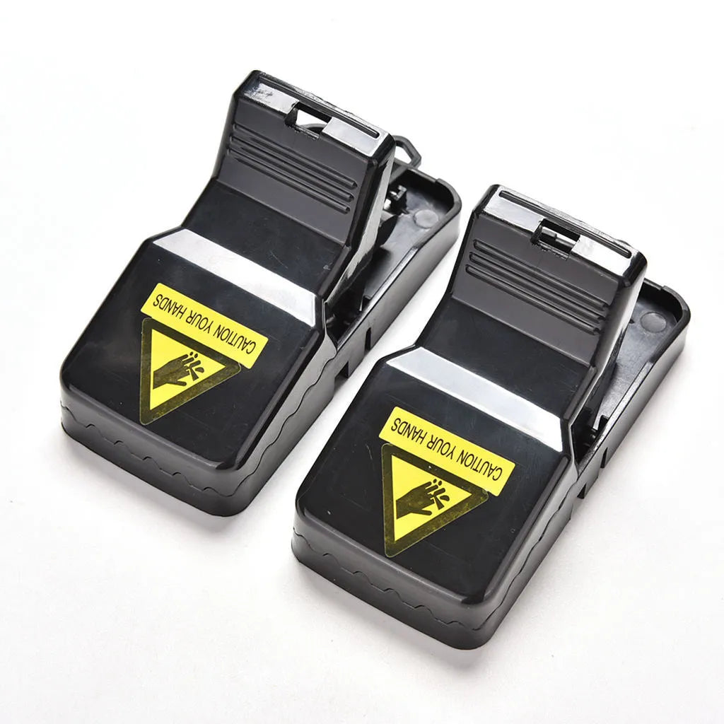 Set of six black plastic snapping mousetraps showing size and smooth surface