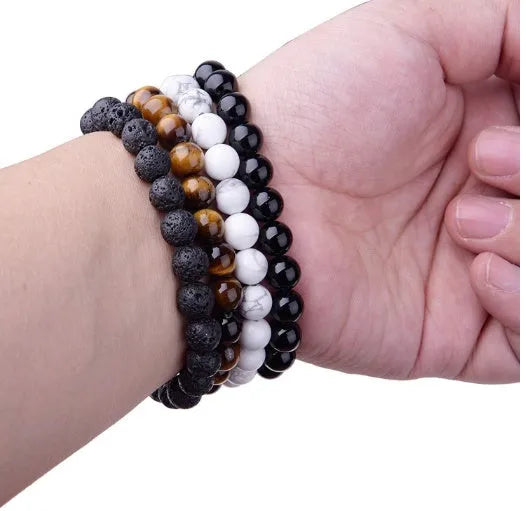 Close-up of a black agate bracelet with 8mm geometric beads on a black elastic cord.