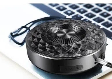 Compact black, orange, and silvery white portable Bluetooth speaker on a table