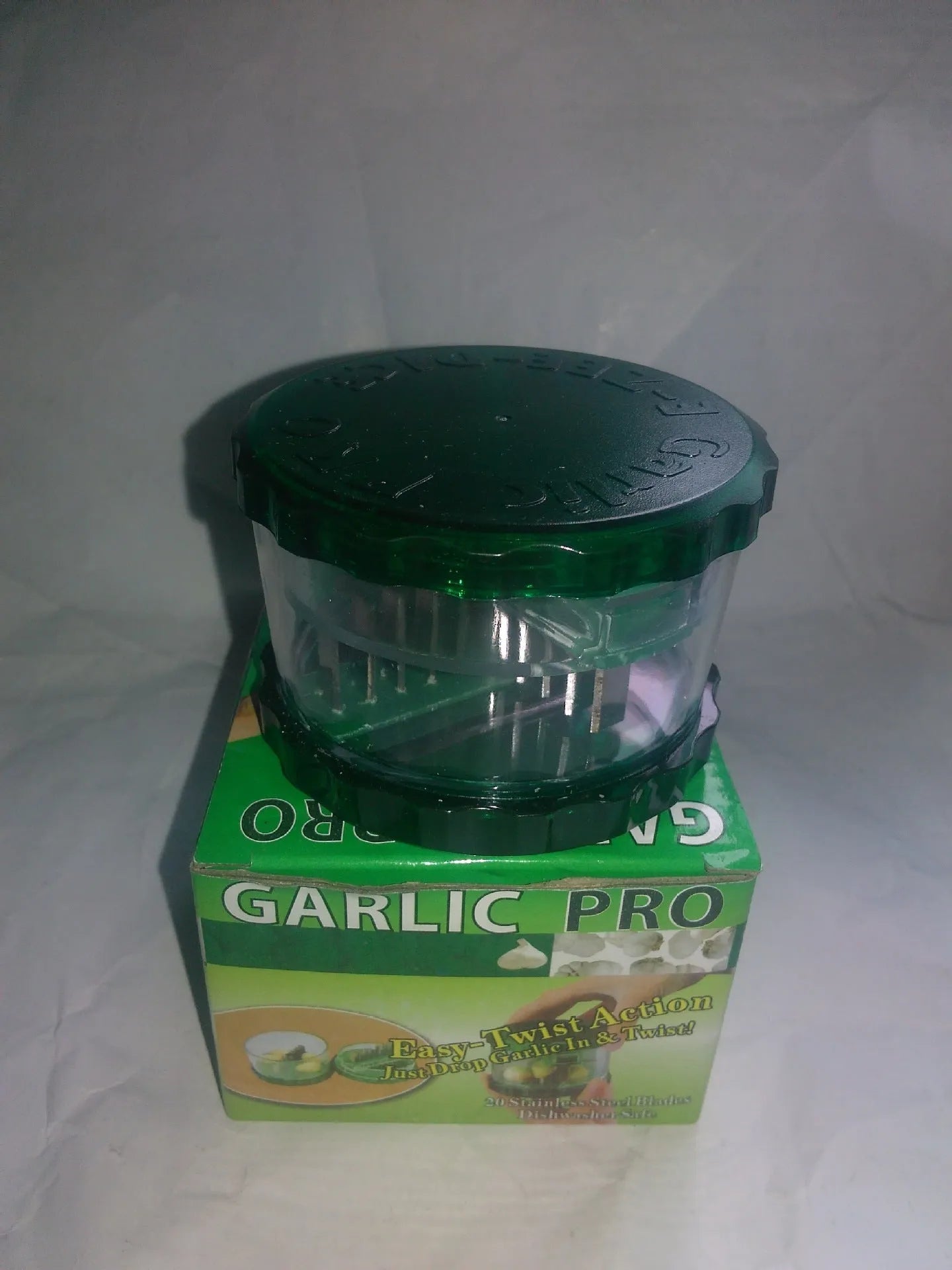 Green transparent PP plastic garlic peeler kitchen gadget on a countertop