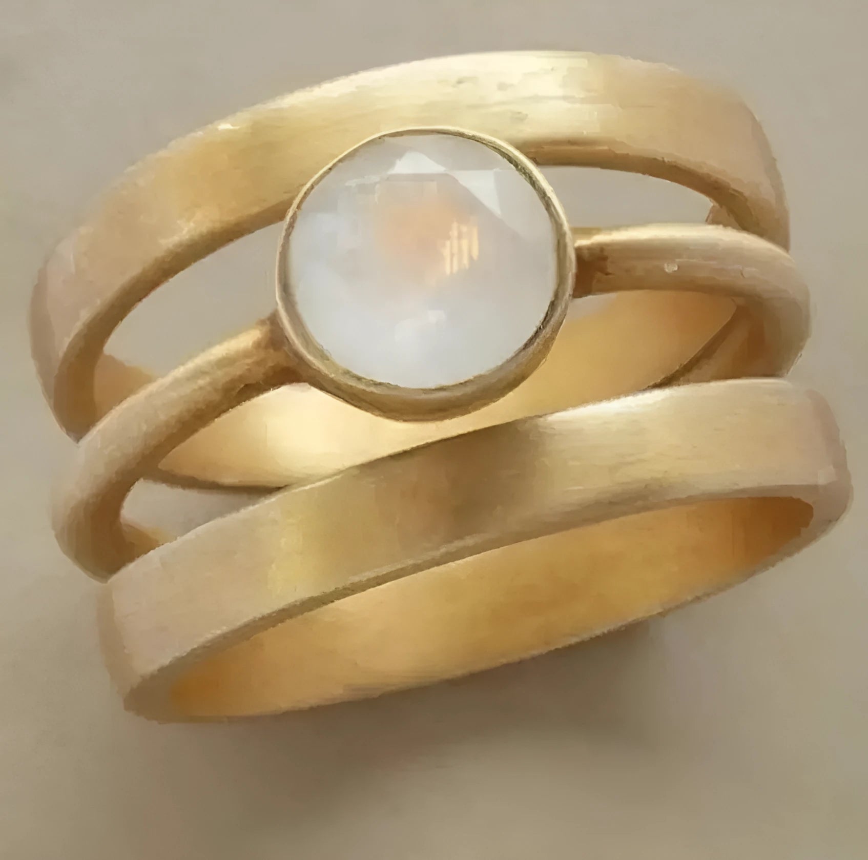 Gold-plated geometric ring with a white chalcedony stone micro-inlaid in a hollow setting.