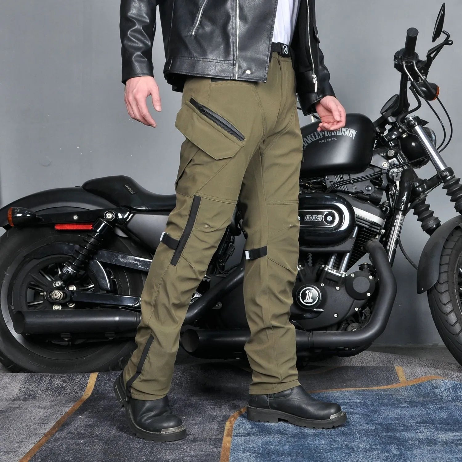 Men's solid green waterproof motorcycle cycling pants laid flat, showing belt and protective gear set.