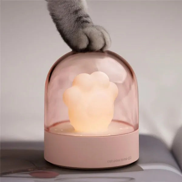 Cute grey or pink cat paw shaped USB rechargeable night light with music box on a desk.