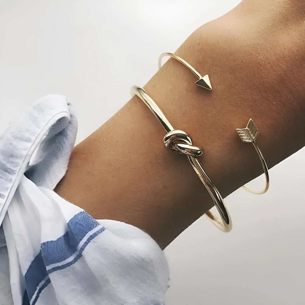 Women's gold vintage cuff bracelet with arrow and knotted design on wrist