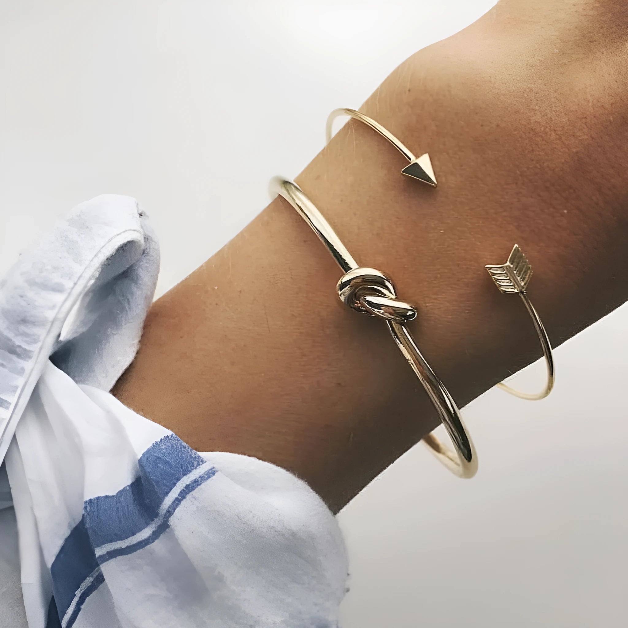 Women's gold vintage cuff bracelet with arrow and knotted design on wrist