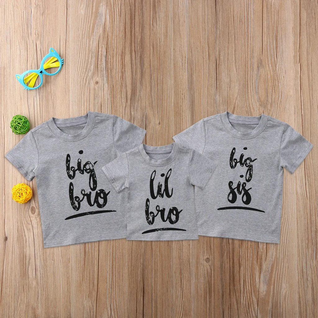 Grey cotton children's t-shirt with printed sibling graphic, showing size range from 60cm to 140cm.