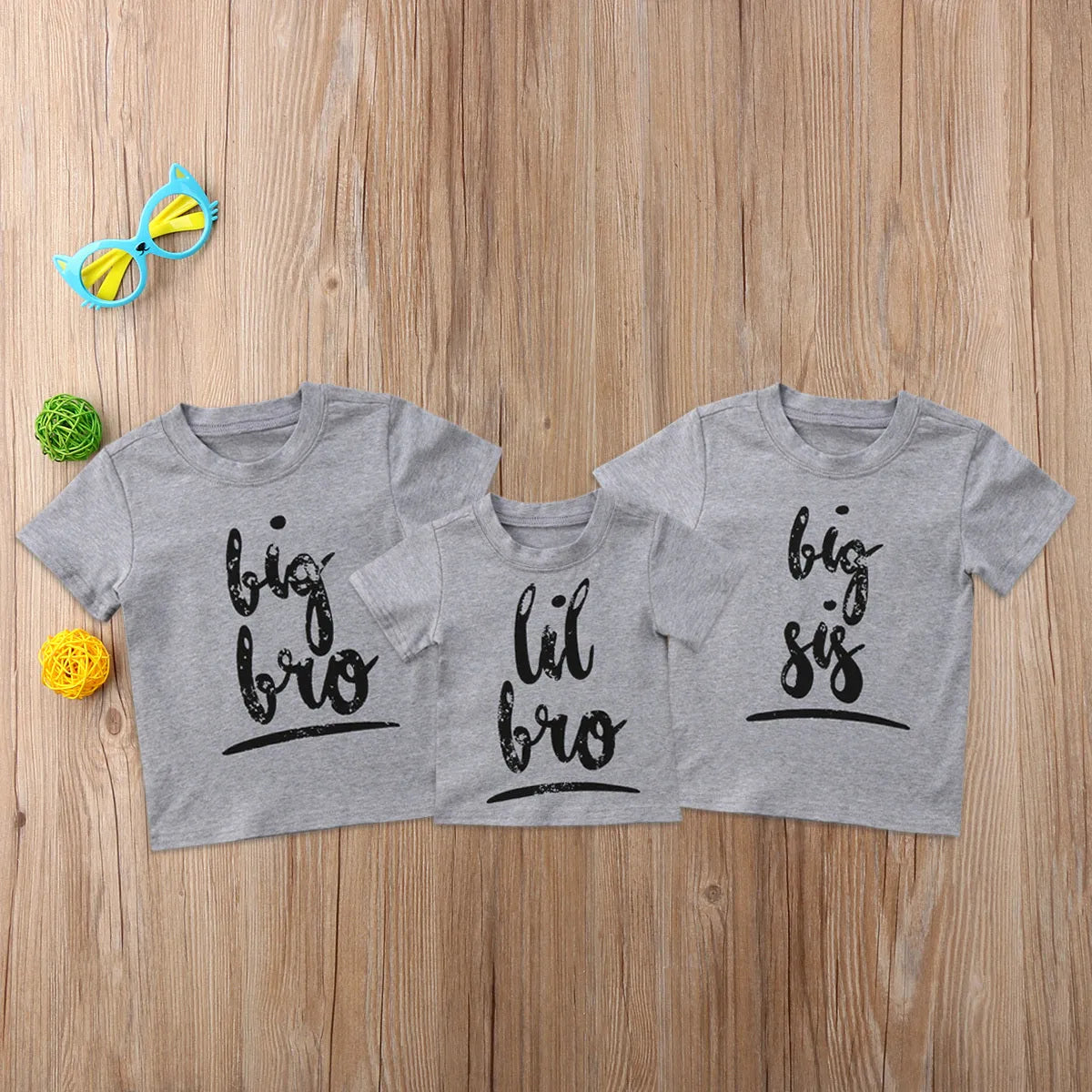 Grey cotton children's t-shirt with printed sibling graphic, showing size range from 60cm to 140cm.