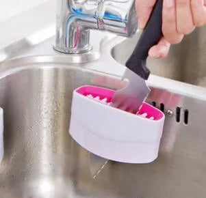 Blue kitchen cleaning brush with suction cup showing knife and fork design for washing fruits and vegetables