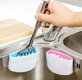 Blue kitchen cleaning brush with suction cup showing knife and fork design for washing fruits and vegetables