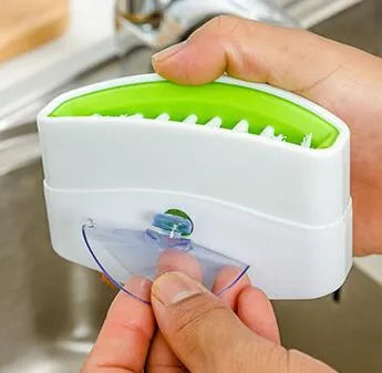 Blue kitchen cleaning brush with suction cup showing knife and fork design for washing fruits and vegetables