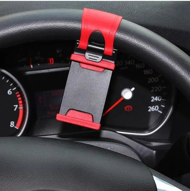 Black universal steering wheel phone holder clip mount attached to a car steering wheel.