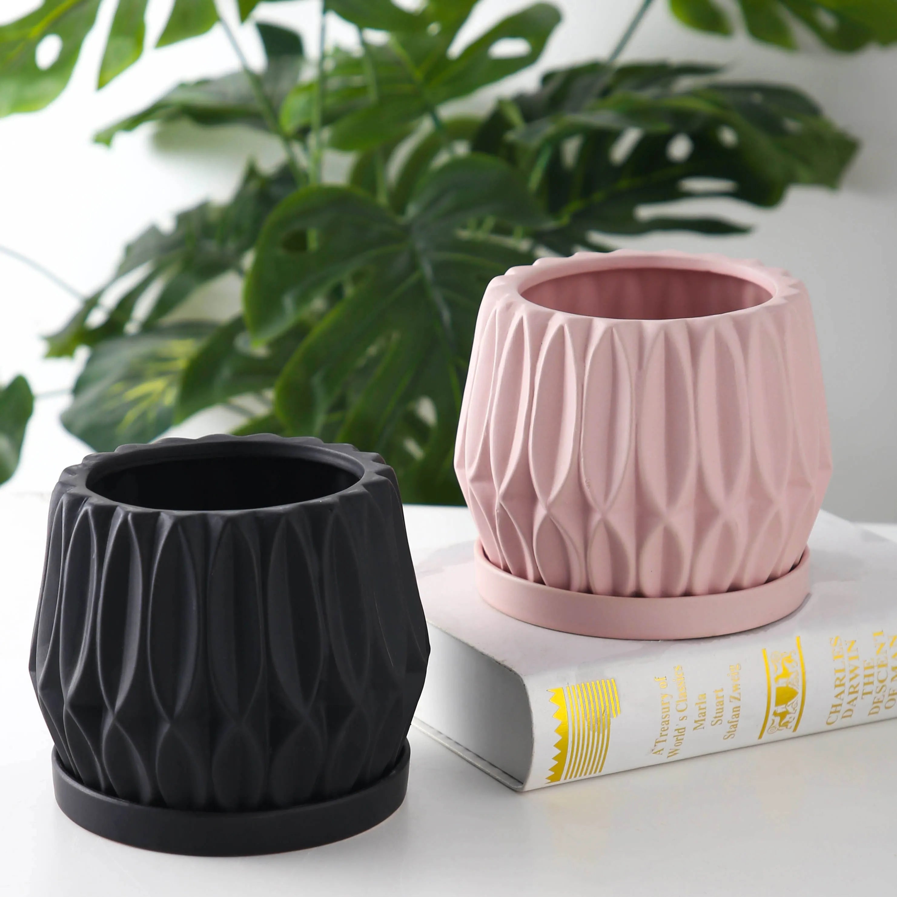 A simple grey ceramic flowerpot, medium-sized, for tabletop or floor plants.