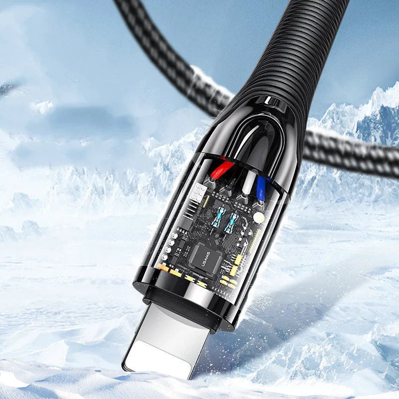 Black braided lightning data cable with zinc alloy connector next to an iPhone 12.