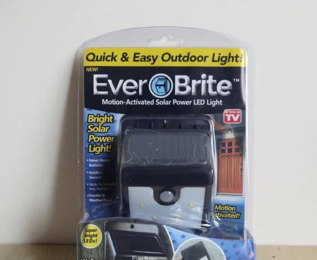 White solar-powered outdoor LED motion sensor light unit mounted on a wall.