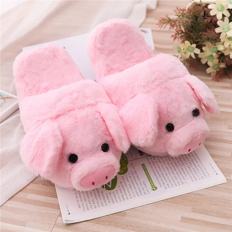 Pink pig-shaped plush floor slippers with a soft, textured surface and cushioned sole.