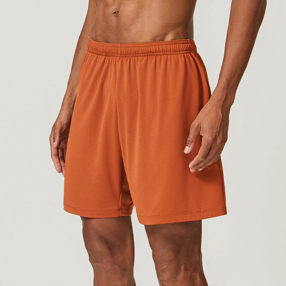 Men's double-layer quick-dry running shorts in brick red colour on a mid-waist fit model.