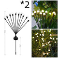 Solar-powered LED garden light with multiple heads on a stainless steel stake, placed in soil.