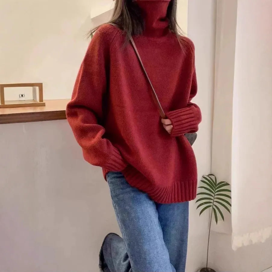 Women's loose grey turtleneck sweater with a thick 3D patterned texture and curling collar.