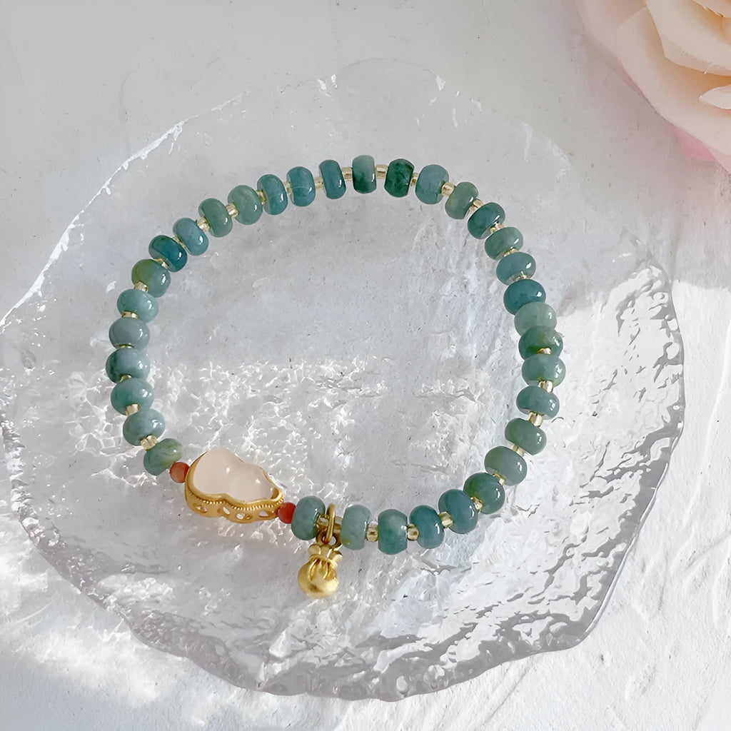 Blue-toned jade bracelet with gourd and peace buckle charms and strawberry quartz accents