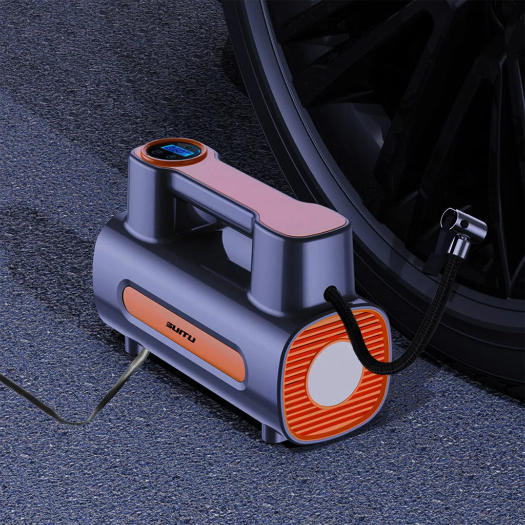 Black portable wireless tire inflator with digital display and USB charging cable on a grey background.