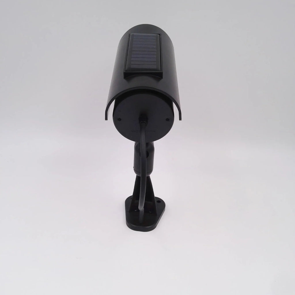 Black plastic gun-shaped dummy security camera with solar panel and red LED light indicator