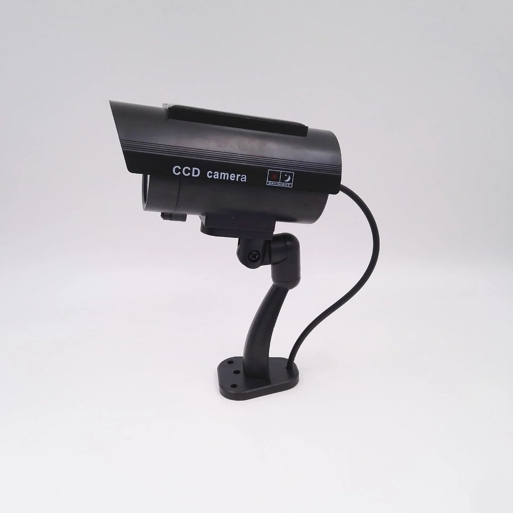 Black plastic gun-shaped dummy security camera with solar panel and red LED light indicator