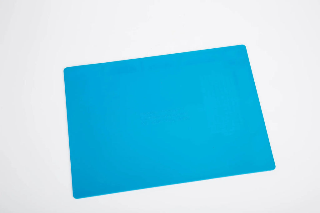 Blue silicone watch repair desk mat lying flat on a workbench.