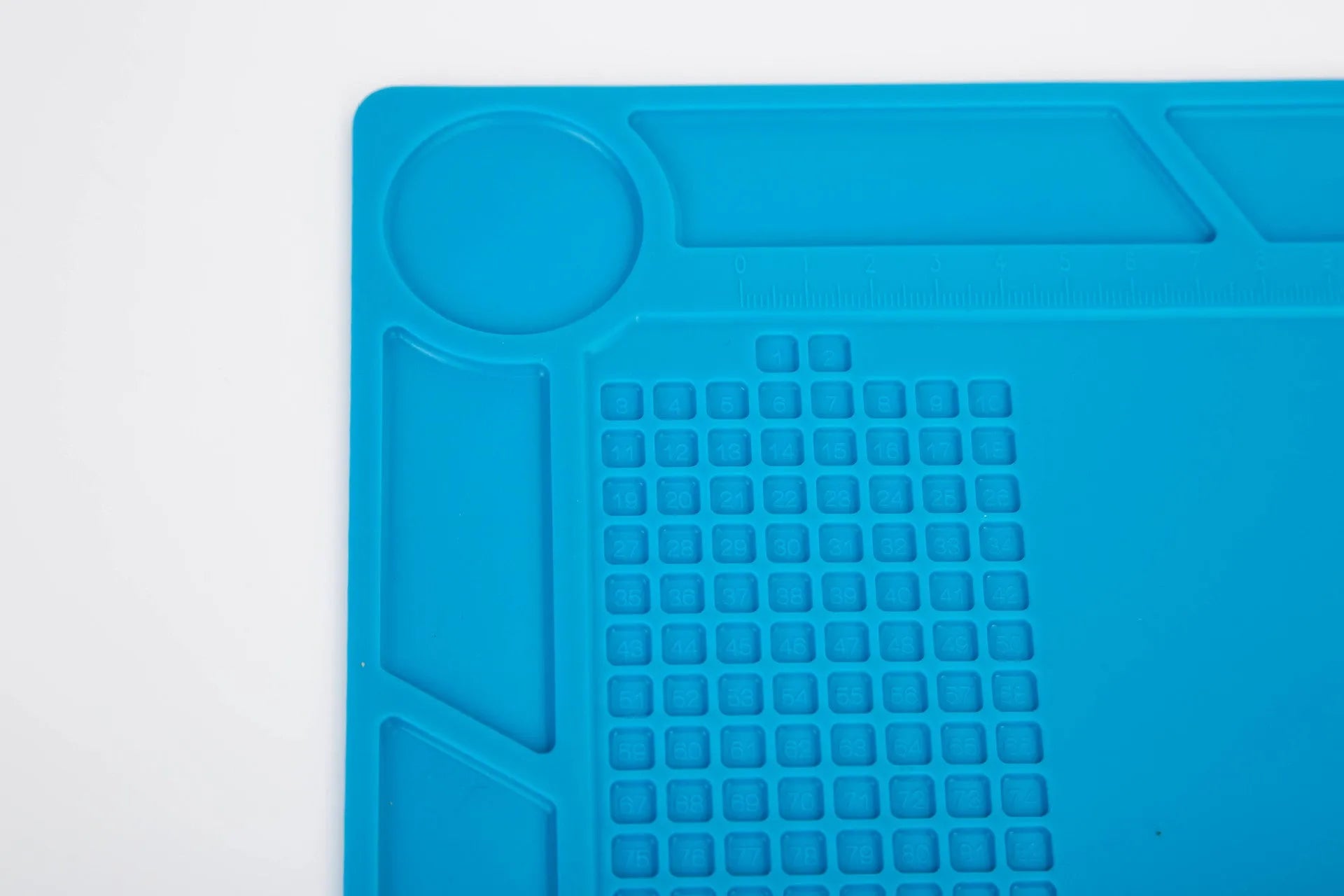 Blue silicone watch repair desk mat lying flat on a workbench.
