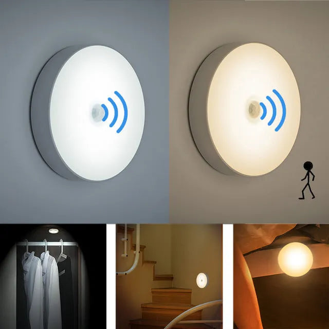 Small round white LED night light with motion sensor and USB charging cable on a table.