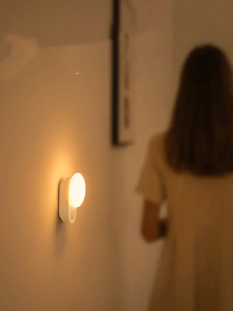 White rechargeable LED night light with motion sensor for bedside use.